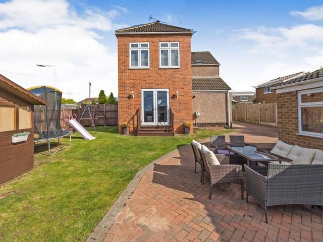 This is the view from the back of the property, with large double doors leading down from the living room into a sizeable garden, complete with lawn and patio area.
