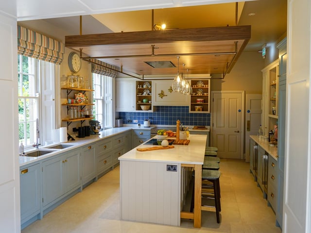 The large kitchen is stocked with four ovens, countless fridges and umpteen shelves heaving with Royal Doulton China, poised for a feast.