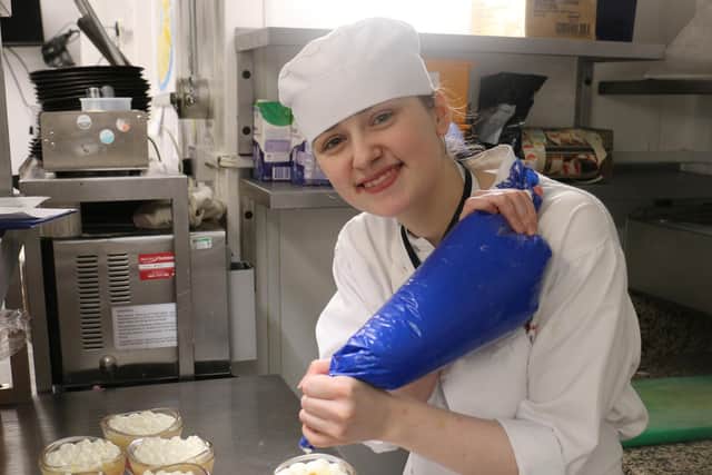 Phoebe Sandford pipes cream onto puddings in the Brasserie 32 kitchens.