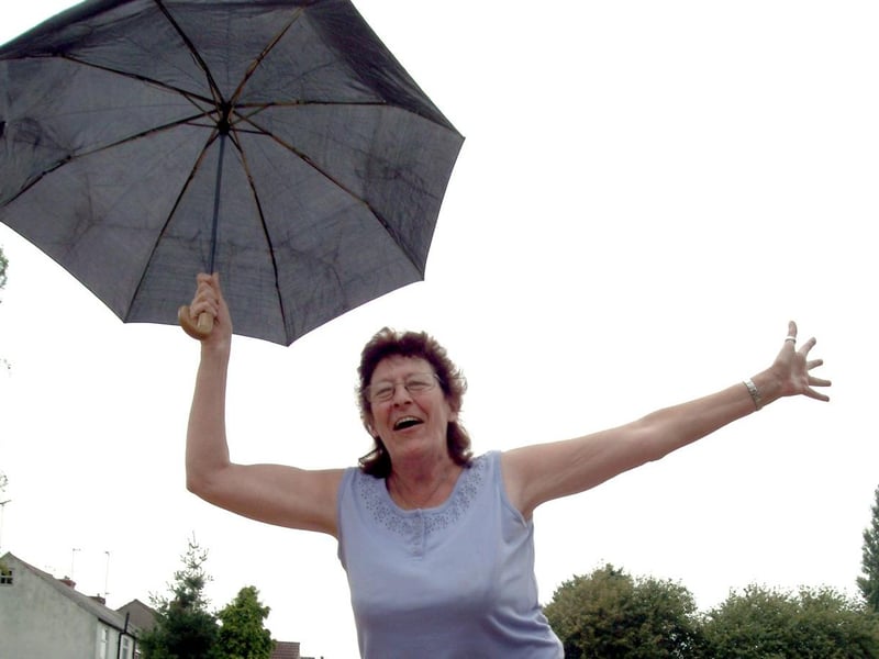 Singing in the rain - Pauline Coupe member of the Poplars Community Association at a fun day in Sutton. 2006.