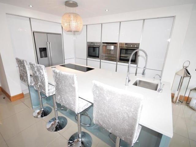 The classy kitchen sweeps you off your feet, with its design and handle-less units, offering plenty of storage space. Neff appliances include two ovens and a coffee machine, while a large island incorporates an inset microwave, sink with mixer tap and boiling water tap, and four-ring ceramic hob with extractor light above.
