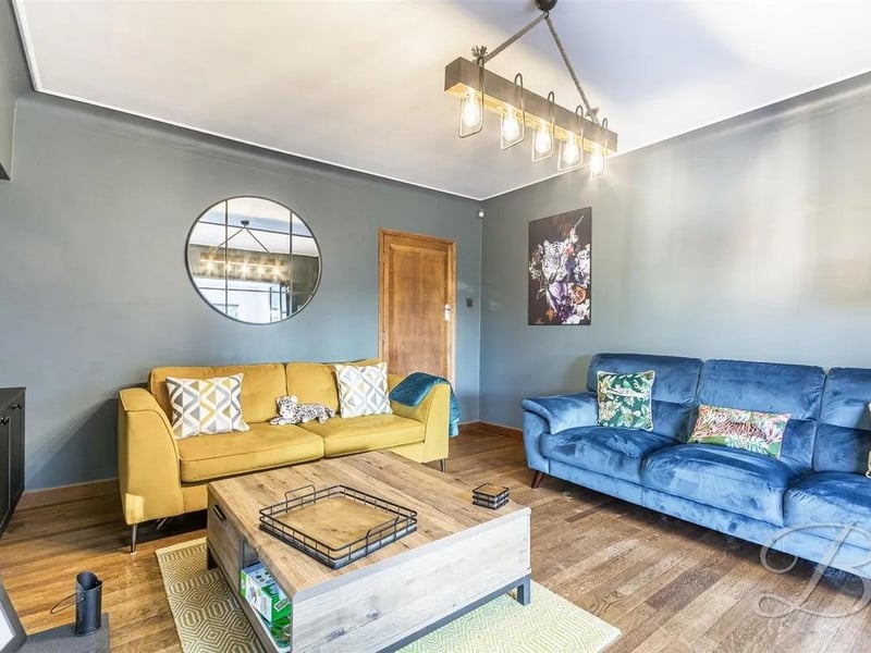 Spacious room with a feature fireplace, patio doors leading into the kitchen and bi-folding doors, creating open plan living with the extension.