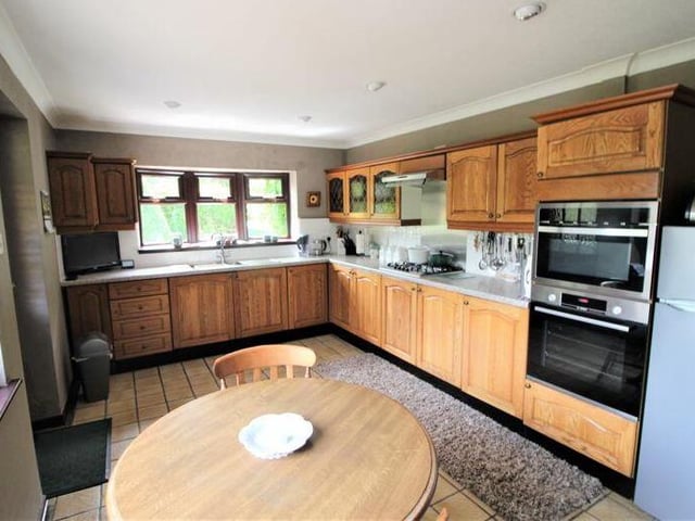 The kitchen is fitted with a range of wall and base units and rolltop work surfaces with inset sink, drainer and mixer tap. It also features a tiled floor, dual-aspect windows and doors leading to a utility room and the dining room.