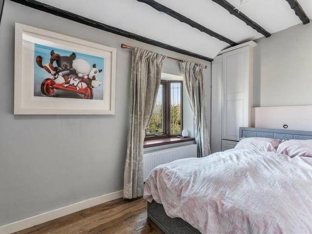 This bedroom is full of character thanks largely to its ceiling beams. There are built-in cupboards, while a cute double-glazed bay window faces the front of the house.