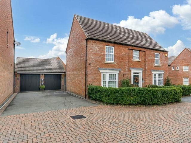 The last photo in our gallery returns us to the front of the Mansfield house, where a private driveway provides lots of off-street parking space and leads to a double garage with ample storage space.