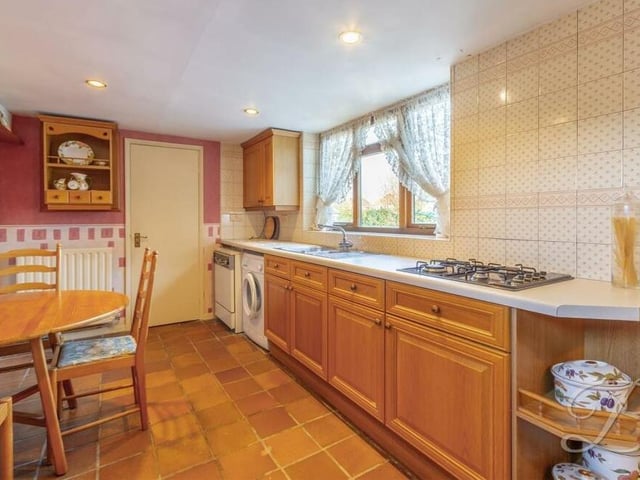 Integrated appliances in the kitchen include an eye-level double oven and a hob with extractor fan above, while there is space and plumbing for a washing machine and dishwasher. Just off the kitchen is a utility room, with units, worktops and an inset sink, plus a store housing the boiler.