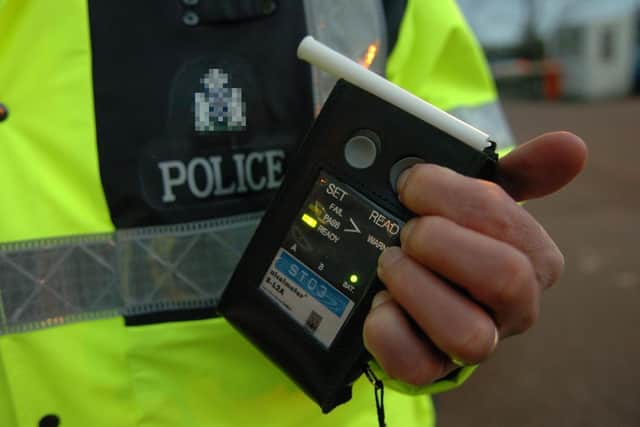 A police officer with a breathalyser.