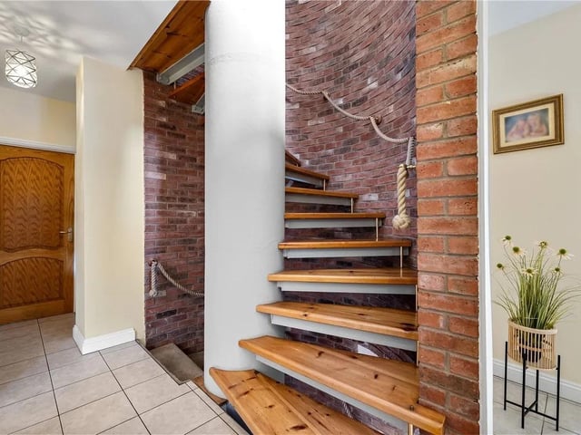 The inner hallway features a spiral staircase leading to the ground floor and second floor.