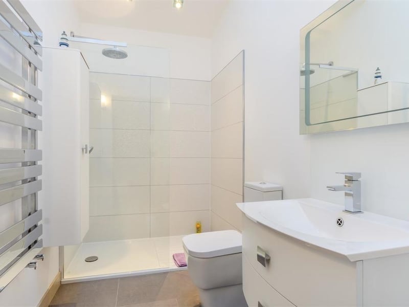 The en suite to the second bedroom is similar to that for the master but without a bath. A suite with chrome fittings consists of a large walk-in shower enclosure, a vanity unit with inset wash hand basin and a WC. There is also a heated mirror, plenty of storage, underfloor heating, a chrome, heated towel-rail and ceiling spotlights.