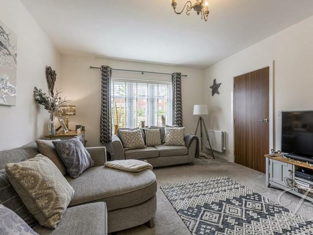 As well as the living area as part of the open-plan space, the ground floor houses this separate, charming living room, with a window facing the front of the Farthing Way house.
