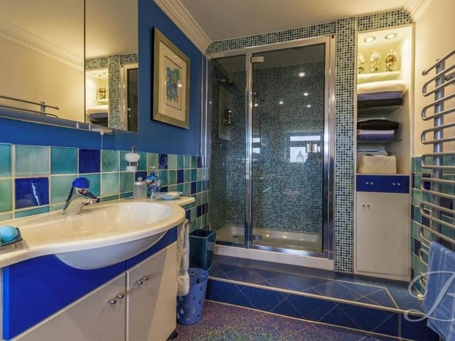 The en suite shower room to the downstairs bedroom can only be described as sparkling. It features a shower cubicle with built-in storage space, a wall-mounted hand wash basin with storage underneath and a heated towel-rail.