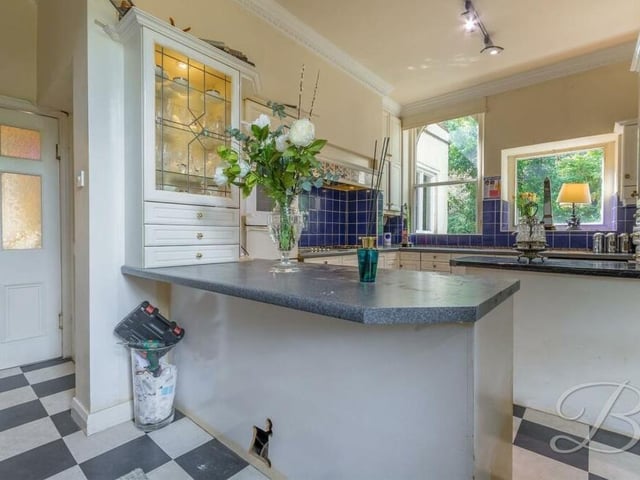 A second look at the kitchen, which is fitted with a range of wall and base units, as well as an inset sink and drainer with mixer tap. It also features a walk-in pantry and two windows at the back of the house.