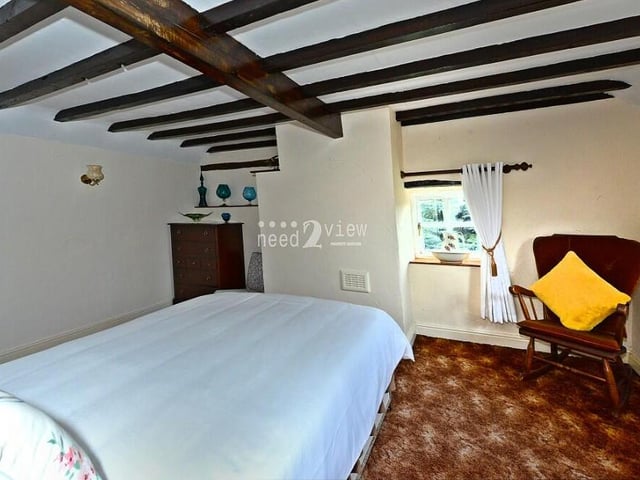 Windows to the front and side, fitted wardrobes and ceiling breams are all features of the third bedroom.