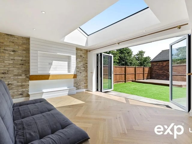 The open plan living area boasts a vaulted skylight, with full-width bi-fold doors opening onto the south-facing garden.