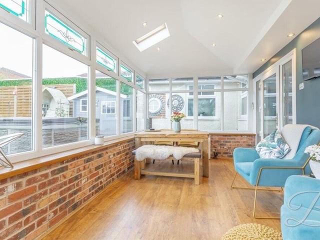 The conservatory boasts large surrounding windows that overlook the garden and patio. Doors to the side also lead out to the garden.