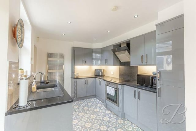 The kitchen is distinguished by a range of modern gloss units and cabinets, work surfaces over and an inset resin sink with drainer. Not even Gordon Ramsay would complain!