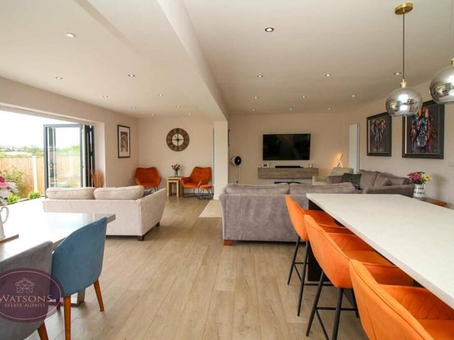As well as the dining table, there is a central island in the kitchen, with more storage space and more seating.