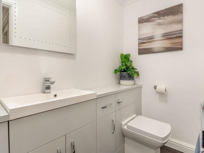 The ground floor at the Forest Town property also features this white two-piece suite. It consists of a low-flush WC and a large vanity unit with inset wash hand basin, work surfaces to each side and storage cupboards beneath. There are further fitted storage units and a chrome, heated towel-rail.