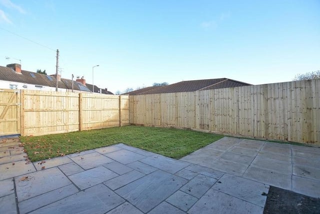 Let's see what the exterior has to offer at Kings Court. This is the garden at the side, featuring a lawn and an Indian sandstone patio and path. It is fully enclosed, offering a good degree of privacy.