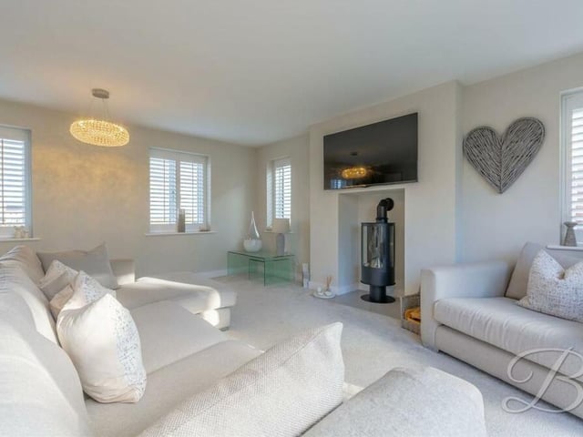 Across the hallway from the open-plan section of the house is this charming and cosy lounge. With a carpeted floor and underfloor heating, there are windows facing the front of the property.