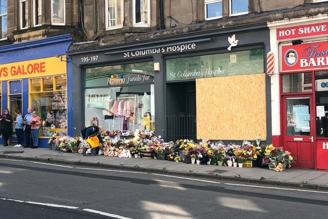 Flowers and toys were piled at the charity shop where the tragic crash occurred