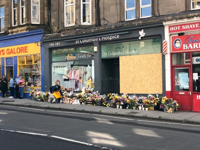 Flowers and toys were piled at the charity shop where the tragic crash occurred