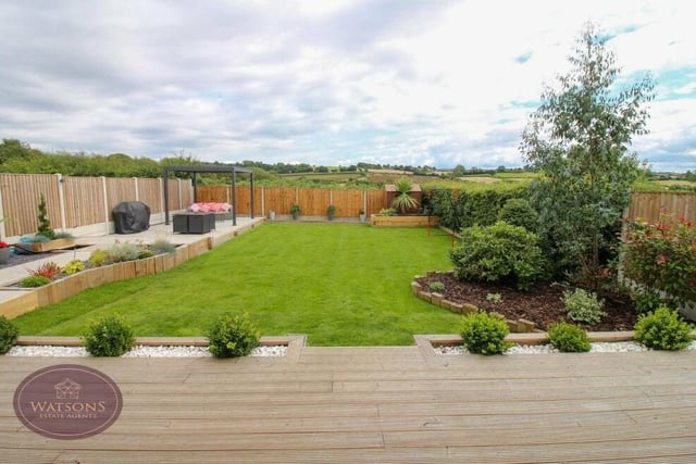 The final photo of our gallery gives you one last look at the rear garden. Enclosed by timber fencing, it also boasts a pond and decorative flowerbed borders.