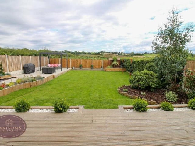 The final photo of our gallery gives you one last look at the rear garden. Enclosed by timber fencing, it also boasts a pond and decorative flowerbed borders.