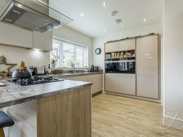 At the other end of the open-plan space is this modern and attractive kitchen, which features a range of integrated appliances.