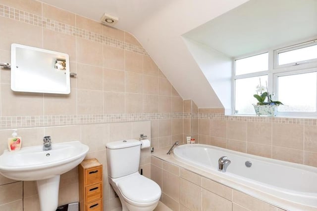 Completing our tour of the interior is this family bathroom. It is fitted with a bath that has an extendable shower head, a wash hand basin, WC, tiled walls and splashbacks, tiled flooring, an extractor fan and a towel radiator.