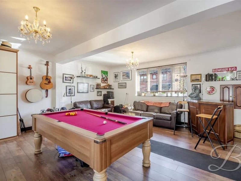 The spacious games room features windows to the front and rear, and patio doors to the rear garden. There’s plenty of space for a pool table or other recreational activities, with wooden features throughout and two central heating radiators for comfort.