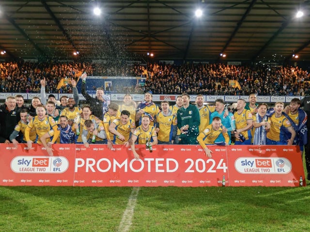 Mansfield Town celebrate promotion after beating Accrington Stanley at home on 16th April 2024.