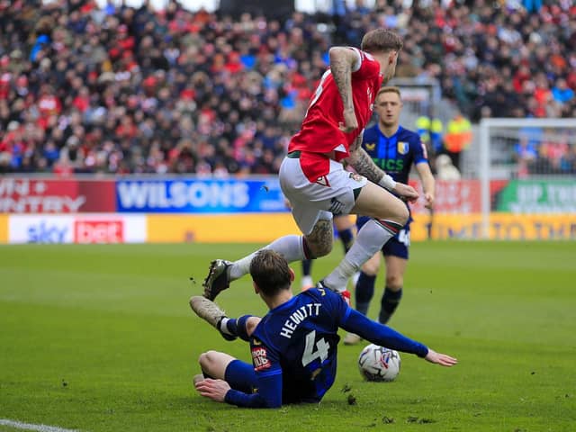Mansfield Town defender Elliott Hewitt gets in an early tackle against Wrexham AFC at the STōK Cae Ras, 29 Mar 2024Photo credit : Chris & Jeanette Holloway / The Bigger Picture.media