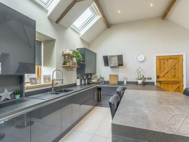 Next stop is the sleek, contemporary kitchen, which is fully equipped with high-end appliances and stunning cabinets, units and work surfaces.