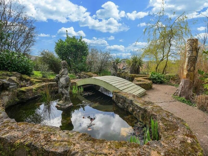 One of the main features of the delightful rear garden is this pond, complete with ornamental bridge and statue.