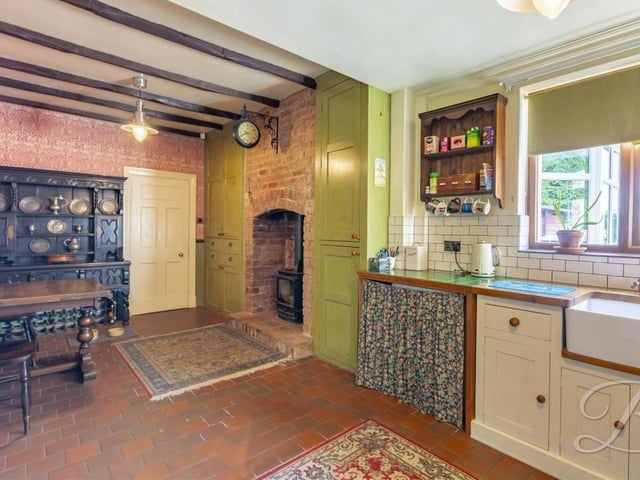 A fourth and final shot of the kitchen, where there is space for a free-standing cooker. Coving to the ceiling, a cast-iron radiator, panelling and a window facing the front of the bungalow add to its appeal.
