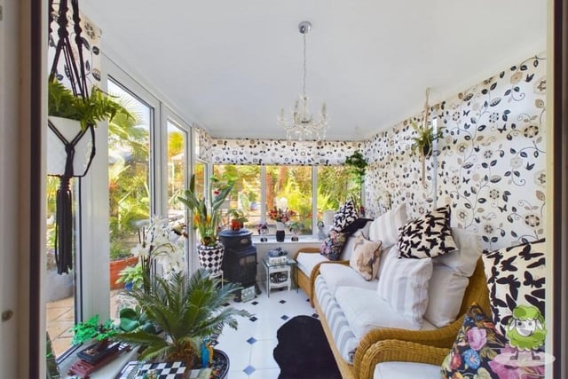 Flowing seamlessly from the dining room is this super sun room, which offers panoramic views of the property's amazing tropical garden. French doors open on to that garden too,
