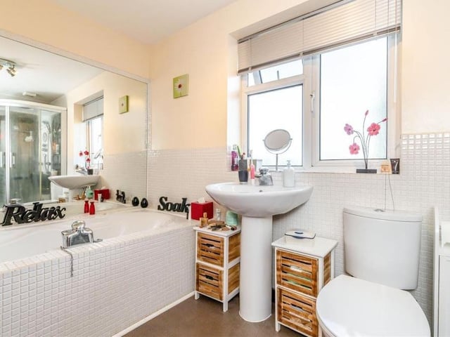 The master bedroom also has access to this en suite bathroom with chrome fittings. It comprises a large shower enclosure with seat and body jets, a tiled inset Jacuzzi bath-tub with mixer tap, pedestal wash hand basin and low-flush WC. There is also a heated towel-rail.