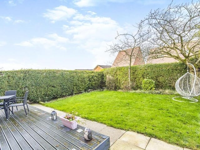 The garden at the back of the house is easy to maintain. There is a lawn and a raised, decked seating area.