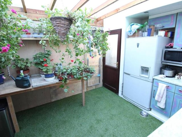 The utility room, currently adorned with flowers, has plumbing for an automatic washing machine and a dishwasher. A very handy space next to the garden room.