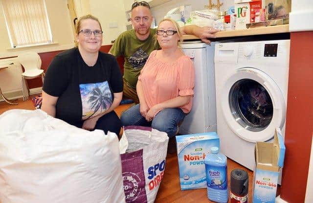 Haylea Williams, Michael Ratcliffe and Kirsty Ratcliffe at the temporary laundry at the Bowne Street Salvation Army.