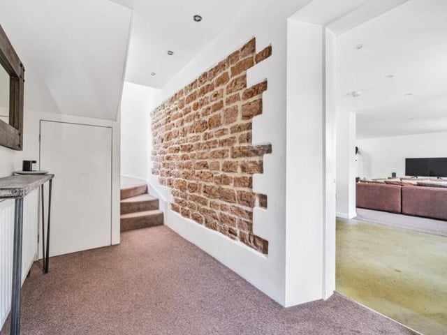 It's time to take a look upstairs now, which means passing through this entrance hallway, with its striking feature brickwork.