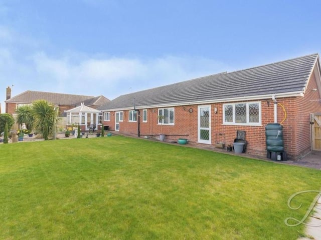 The rear garden is topped off by this large and well-maintained lawn. The whole area is surrounded by mature shrubs and a fence, giving you plenty of privacy.