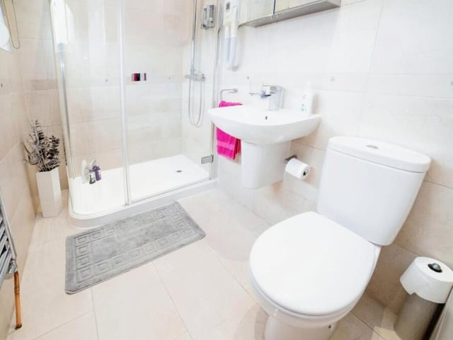 As well as the en suite serving the master bedroom, the bungalow contains this impressive shower room, with shower cubicle, wash basin, WC and towel rail.