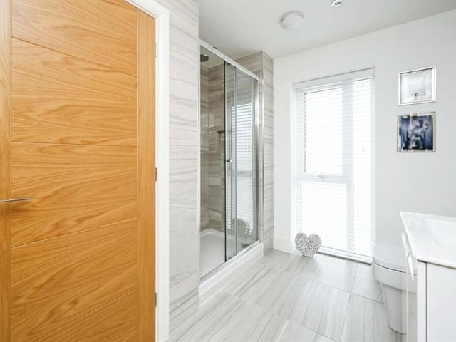 An impressive shower room completes the first-floor layout. It consists of a double shower cubicle with rainfall shower, double vanity wash hand basin, WC, heated towel-rail, tiled flooring, partly tiled walls, spot lighting and a full-length double-glazed window facing the front of the property.