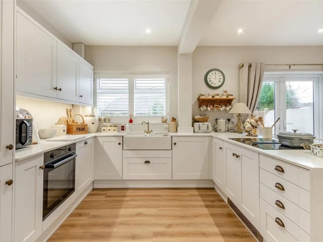 Integrated appliances include a single electric oven, four ring induction hob with down draught extractor, fridge/freezer and dishwasher.