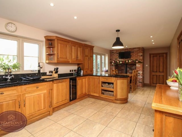 Granite work surfaces in the kitchen incorporate an inset one-and-a-half bowl sink and drainer unit. Beneath you, the flooring is tiled, while above you, there are ceiling spotlights.