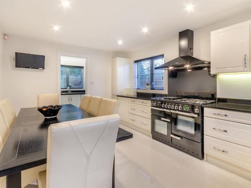 We move now into the modern kitchen/diner, which was fitted by reputable Mansfield firm Henshaws. It boasts a range of high-gloss, light cream cabinets, comprising wall cupboards, base units and drawers with chrome handles, all complemented by black granite worktops.