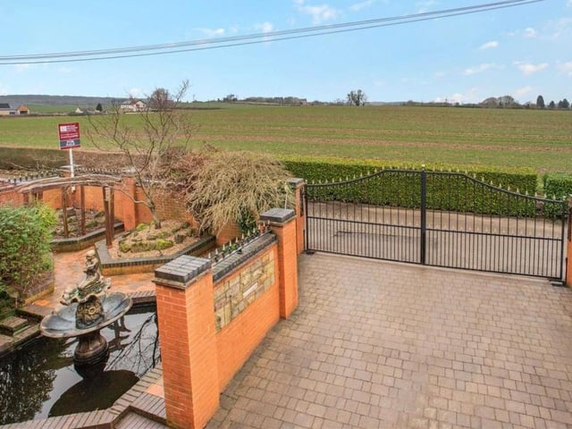 Returning to the front of the house, this photo shows the remote-controlled, electric gates that provide the entrance to Westbank. The property is approached via country lanes, beyond which are open fields.