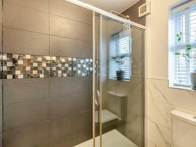 Completing the first-floor family shower room is this double-width, tiled shower enclosure with rainfall shower and additional shower attachment. The room also benefits from a ceramic tiled floor, a heated towel-rail and partly tiled walls.
